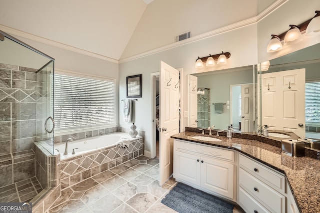 bathroom featuring vanity, vaulted ceiling, a stall shower, visible vents, and a garden tub