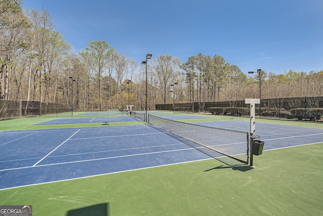 view of tennis court with fence and community basketball court