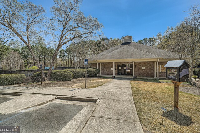 view of front of house with a chimney, fence, and brick siding