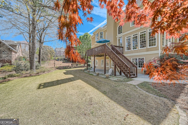 view of yard featuring a patio, a deck, and stairs