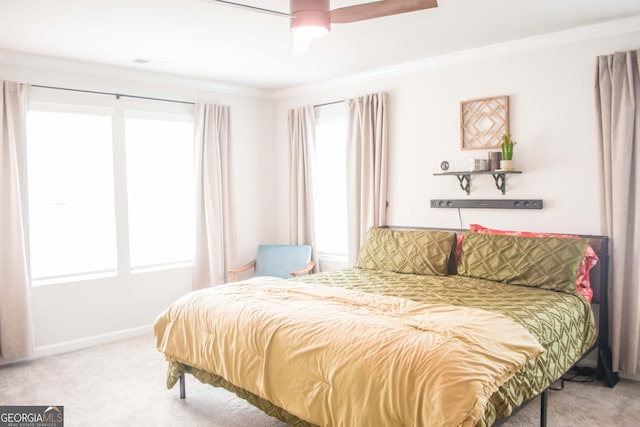 carpeted bedroom featuring baseboards, ceiling fan, and crown molding