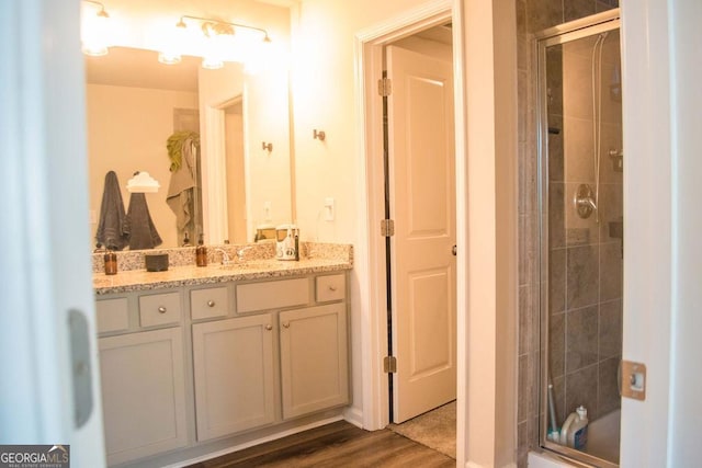 bathroom with a shower stall, vanity, and wood finished floors