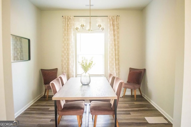 dining area with dark wood-style floors, baseboards, visible vents, and a notable chandelier