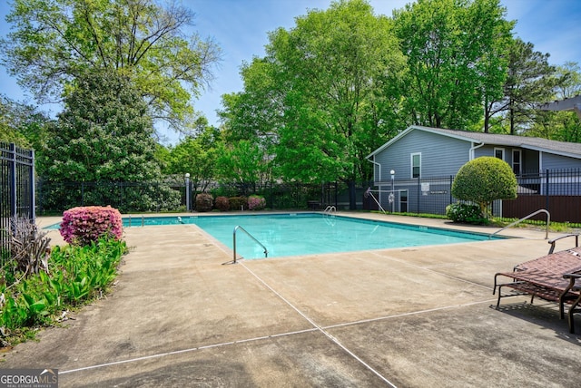 community pool featuring fence and a patio