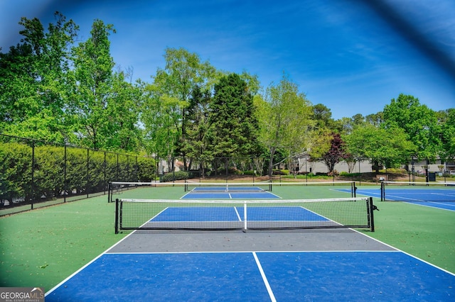 view of tennis court featuring fence and community basketball court