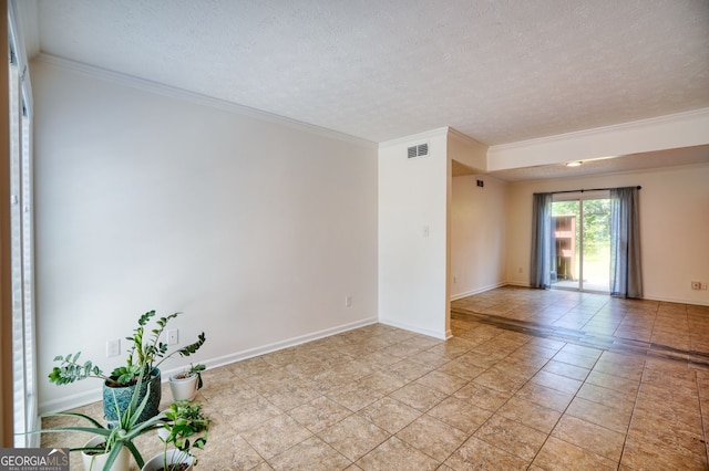 empty room with visible vents, ornamental molding, and a textured ceiling
