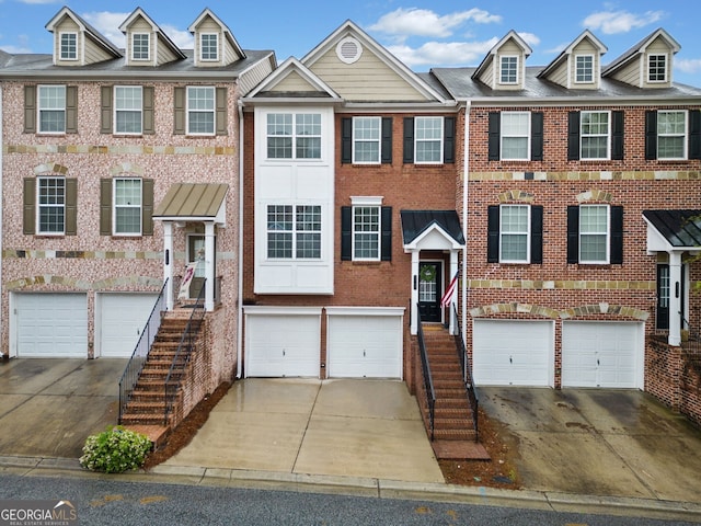 townhome / multi-family property featuring brick siding, driveway, and an attached garage