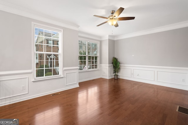 empty room featuring visible vents, a ceiling fan, crown molding, and wood finished floors