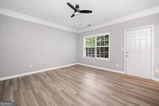spare room featuring wood finished floors, baseboards, ornamental molding, and ceiling fan