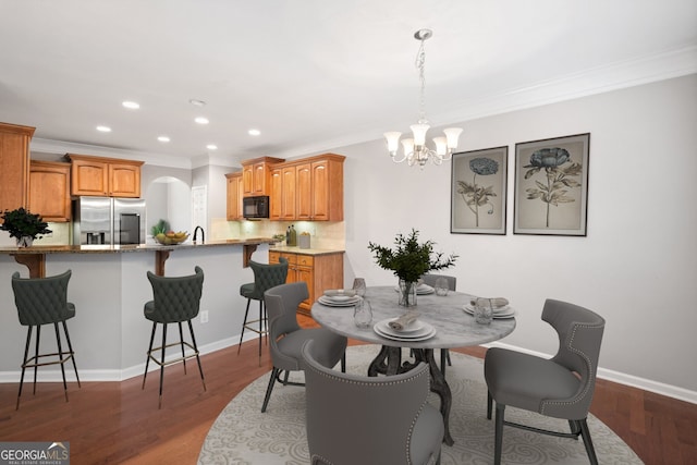dining room featuring recessed lighting, dark wood-type flooring, a notable chandelier, and ornamental molding