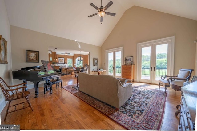 living area featuring high vaulted ceiling, french doors, a ceiling fan, and wood finished floors