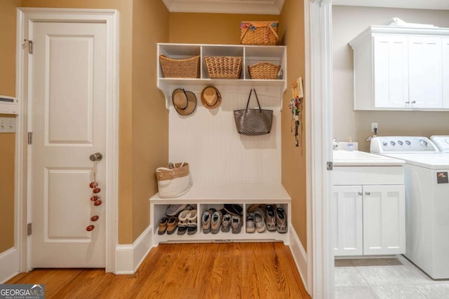 mudroom with light wood-style flooring, a sink, baseboards, and washer / dryer