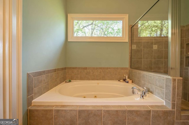 full bath with a jetted tub and tiled shower