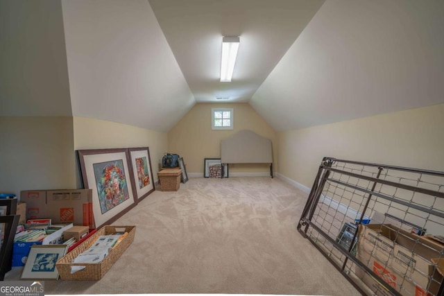 interior space with carpet, baseboards, and vaulted ceiling