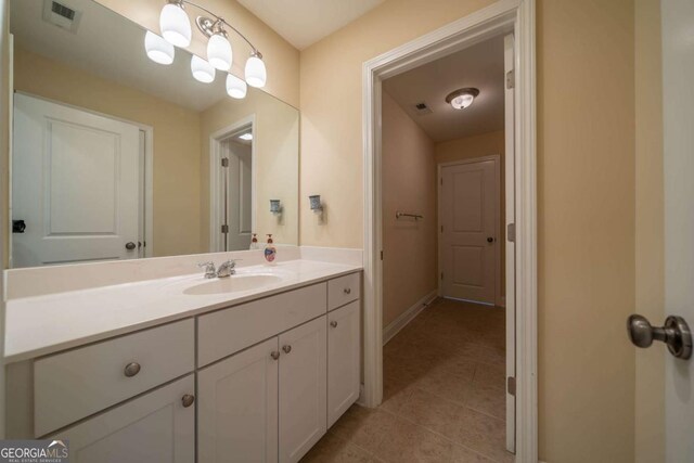 bathroom featuring tile patterned floors, vanity, visible vents, and baseboards