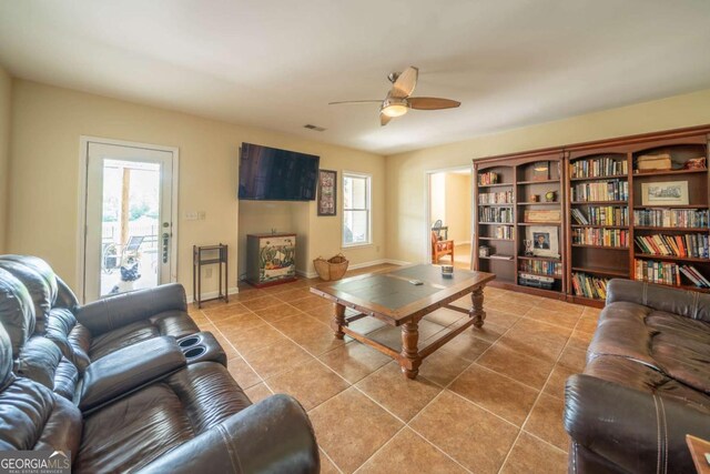 living room with visible vents, baseboards, a ceiling fan, and tile patterned flooring