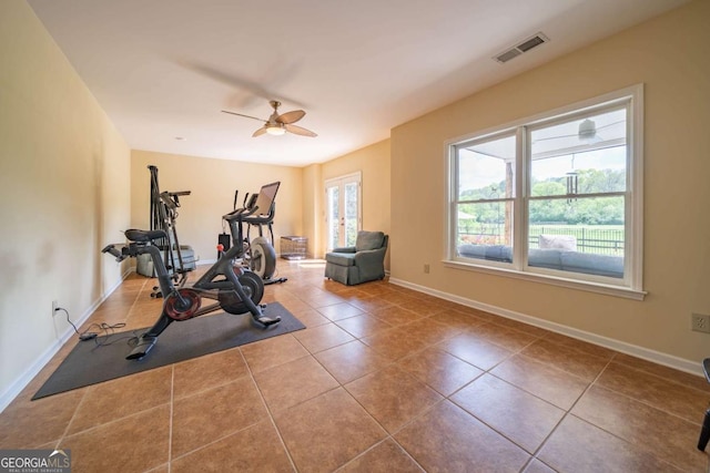 exercise room with visible vents, baseboards, a ceiling fan, and tile patterned flooring