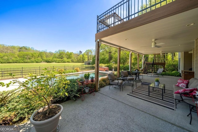 view of patio / terrace with fence, stairway, ceiling fan, and a fenced in pool