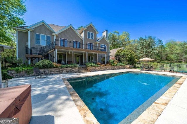 view of swimming pool featuring a patio area, a fenced in pool, fence, and stairway