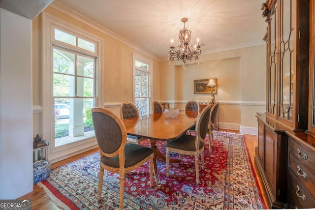 dining area with crown molding, baseboards, an inviting chandelier, and wood finished floors