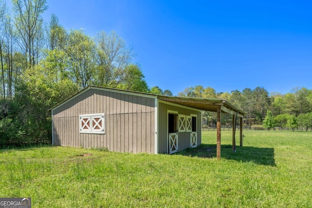 view of pole building featuring a yard and fence