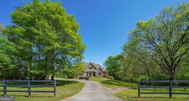 view of front of property with fence and a front lawn
