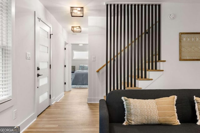 entryway featuring baseboards, stairway, and wood finished floors