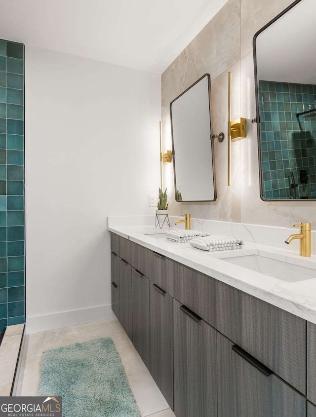 full bathroom with a sink, a tile shower, and double vanity