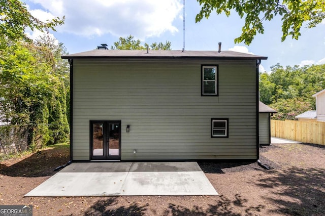 rear view of house featuring french doors, a fenced backyard, and a patio