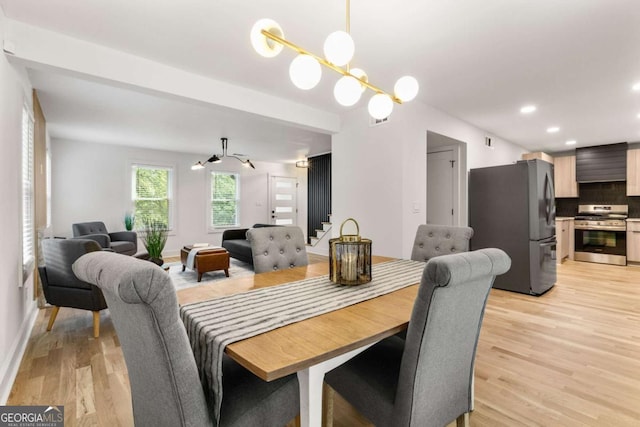 dining room featuring recessed lighting, light wood finished floors, a chandelier, and stairway