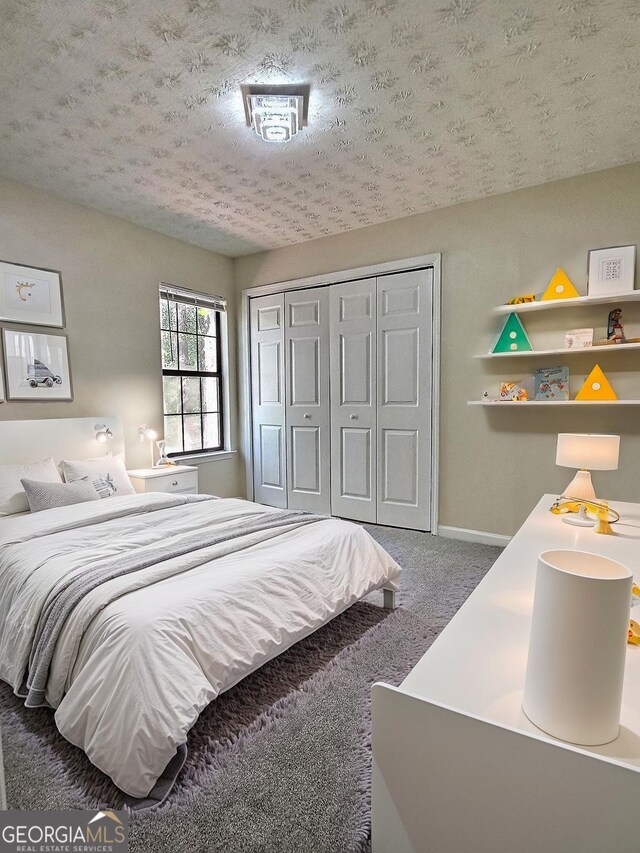 4460 Branchwood Ct, Loganville, GA 30052 - bedroom with a textured ceiling, a closet, baseboards, and carpet floors