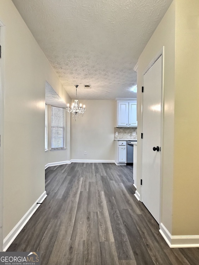 4460 Branchwood Ct, Loganville, GA 30052 - unfurnished dining area with a chandelier, dark wood-type flooring, baseboards, and visible vents