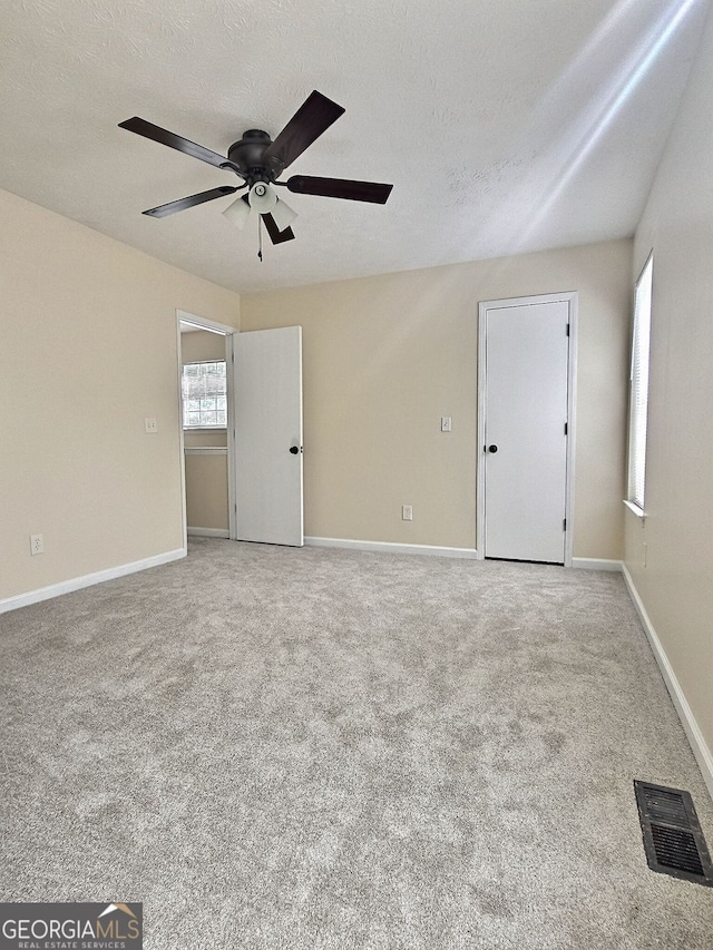 4460 Branchwood Ct, Loganville, GA 30052 - carpeted empty room with visible vents, ceiling fan, baseboards, and a textured ceiling