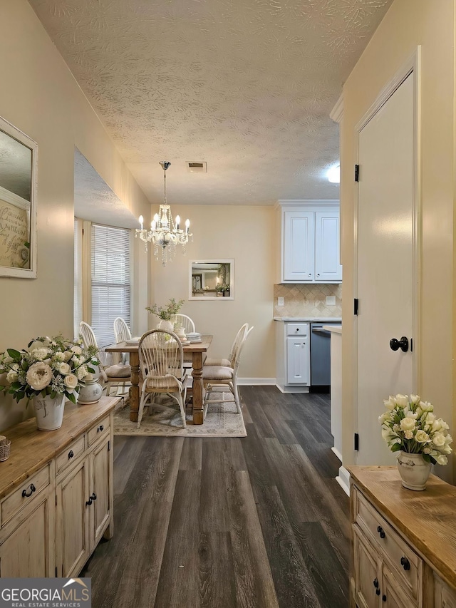 4460 Branchwood Ct, Loganville, GA 30052 - dining space with dark wood finished floors, a textured ceiling, visible vents, baseboards, and a notable chandelier