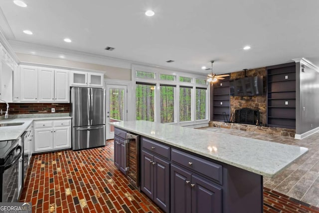 2455 Horseleg Creek Rd SW, Rome, GA 30165 - kitchen with a stone fireplace, freestanding refrigerator, wine cooler, a sink, and electric range oven
