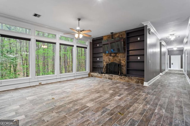 2455 Horseleg Creek Rd SW, Rome, GA 30165 - unfurnished living room with crown molding, ceiling fan, a fireplace, visible vents, and wood finished floors