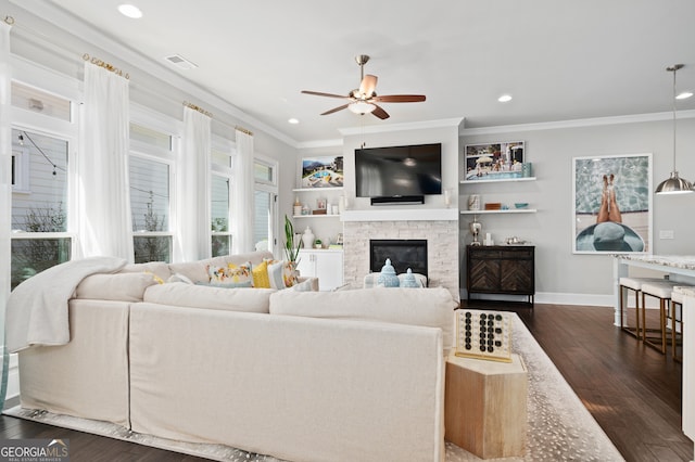 living area featuring ornamental molding, recessed lighting, a fireplace, dark wood-type flooring, and ceiling fan