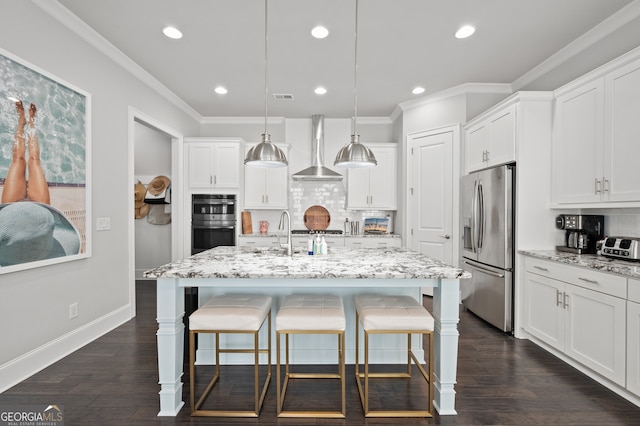 kitchen with wall chimney range hood, a breakfast bar area, crown molding, and appliances with stainless steel finishes