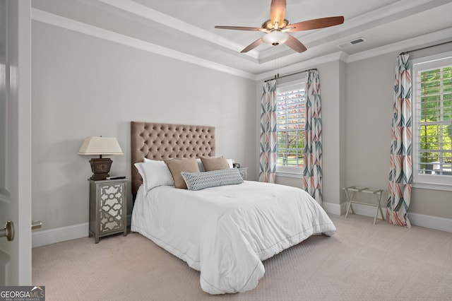 bedroom with carpet flooring, visible vents, a tray ceiling, and baseboards