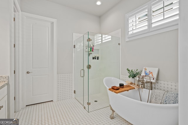 full bath with a shower stall, recessed lighting, vanity, and a freestanding bath