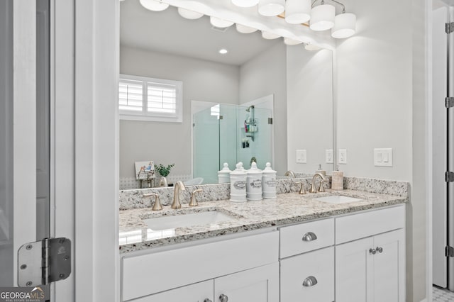 bathroom with a sink, double vanity, and a stall shower