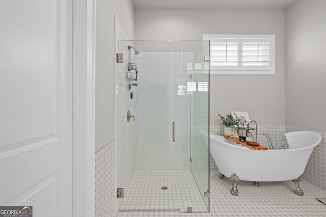bathroom with a shower stall and a freestanding tub