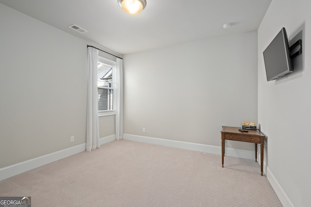 empty room featuring visible vents, baseboards, and light colored carpet