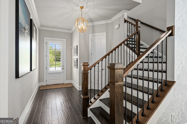 entryway featuring baseboards, a notable chandelier, ornamental molding, wood finished floors, and stairs