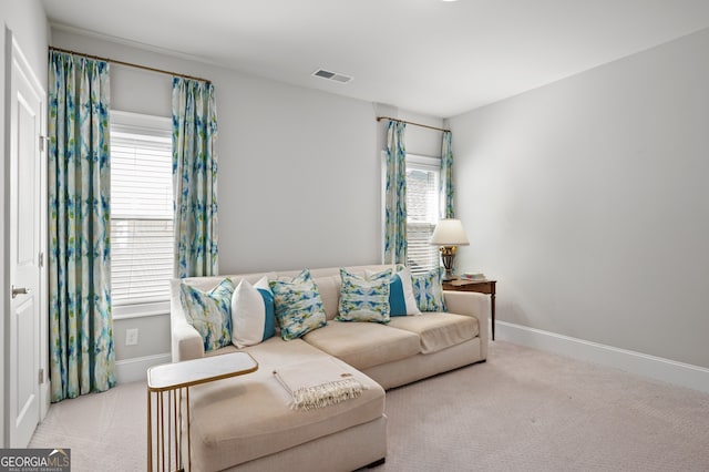 carpeted living room with a healthy amount of sunlight, baseboards, and visible vents