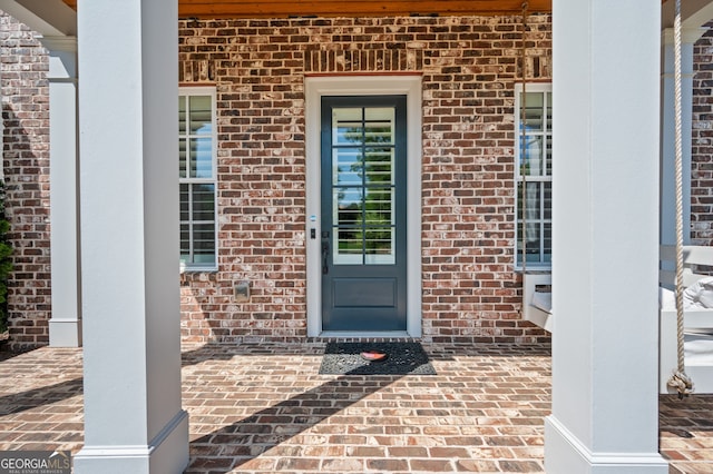 doorway to property with brick siding