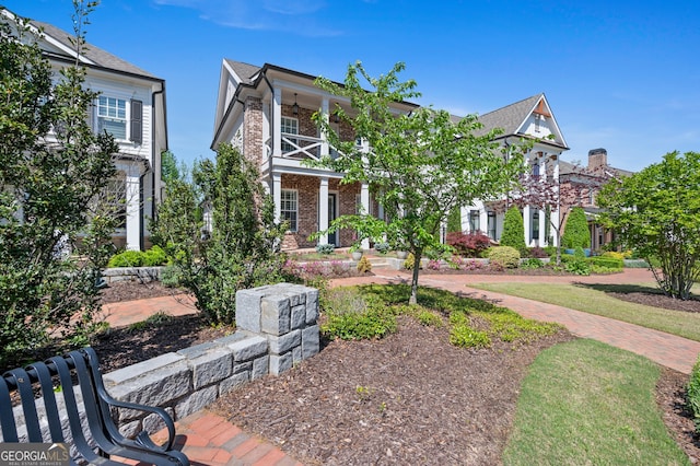 view of front of property featuring brick siding and a balcony