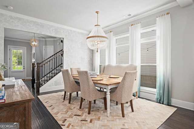 dining area featuring ornamental molding, an inviting chandelier, wood finished floors, and stairs