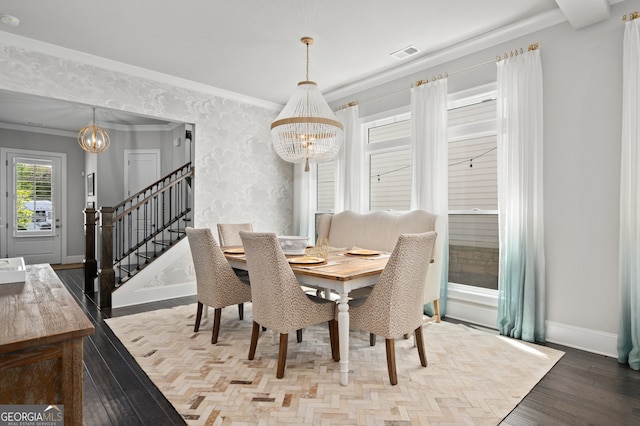 dining area featuring a notable chandelier, baseboards, crown molding, stairs, and wood finished floors