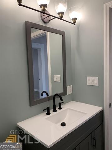 bathroom with a notable chandelier and vanity
